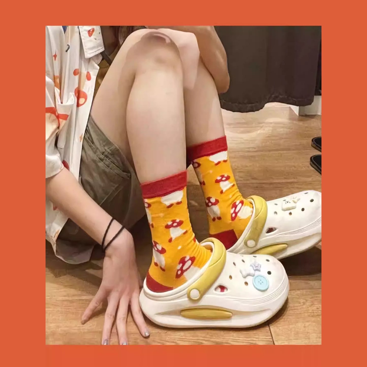 A pair of Delicious in Dungeon (Dungeon Meshi) fan-made mid-crew socks featuring the iconic Walking Mushroom design. The socks showcase the adorable red-capped mushroom with yellow spots and wiggly legs, set against a contrasting background. The vibrant red and yellow color scheme matches the creature's cheerful in-game appearance, while the mid-calf length makes them perfect for cozy or costume wear.