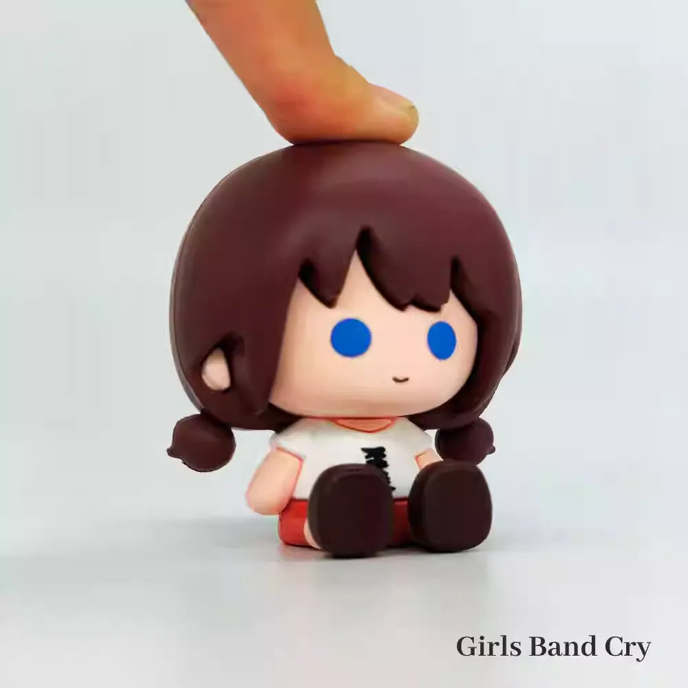 A chibi-style PVC mini figure of Seri from Crying Girls Band, featuring an adorable two-heads-tall design with large, glossy dot eyes and a teary, pouty expression. The figure captures her signature outfit—likely her school uniform or band costume—in soft, pastel colors, with exaggerated tiny hands and stubby legs adding to the cuteness. The compact size and smooth PVC material make it perfect for desk displays or collection shelves.