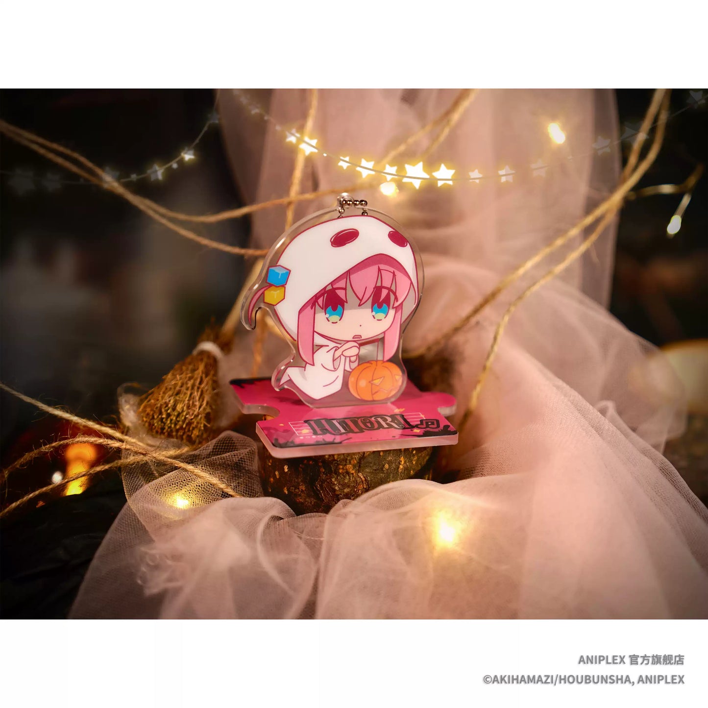 A Halloween theme acrylic mini stand of Bocchi the Rock! character Gotoh Hitori, she's wearing ghost like cloth, with a pumpkin beside her